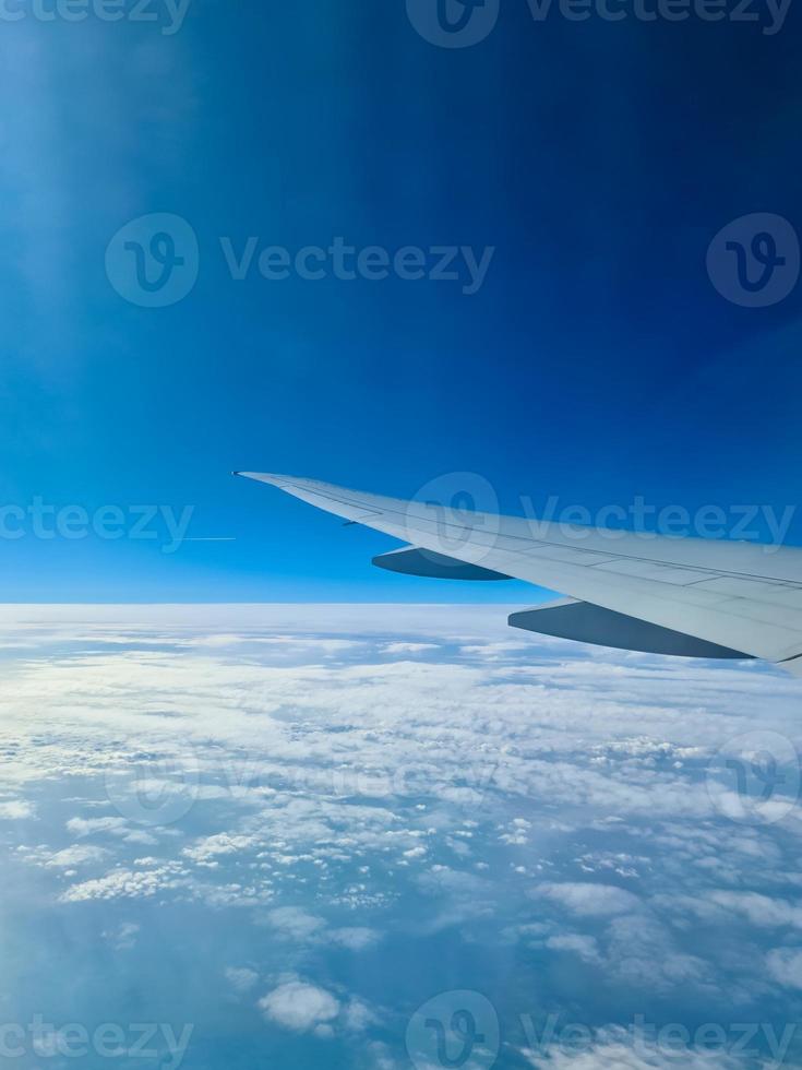 View from an aircraft onto the wing and clouds below. photo