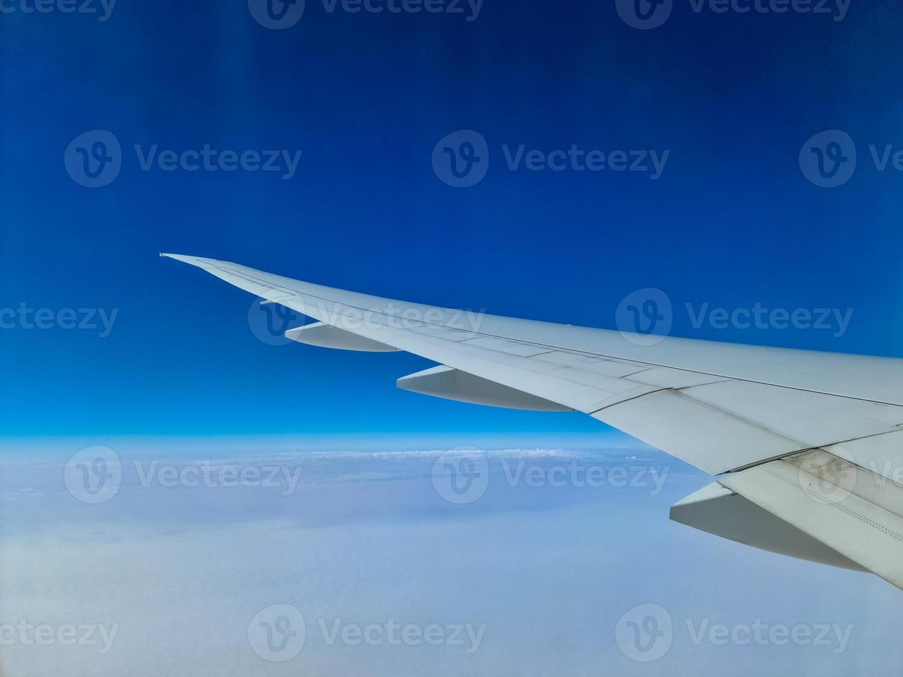 View from an aircraft onto the wing and clouds below. photo
