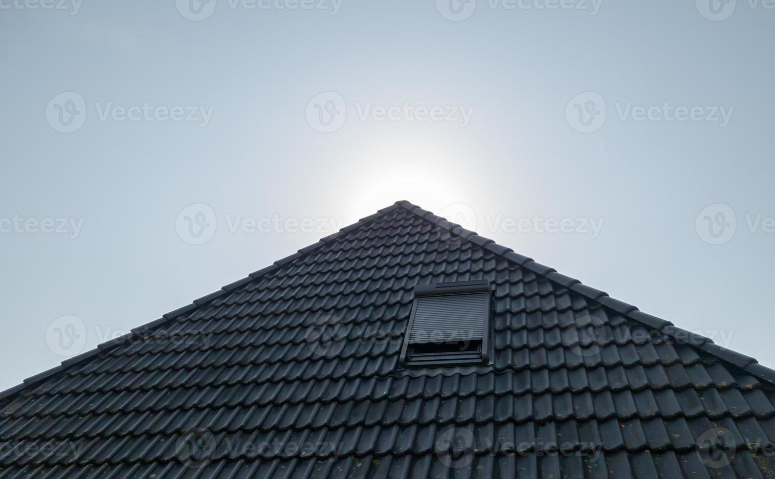 Open roof window in velux style with black roof tiles. photo