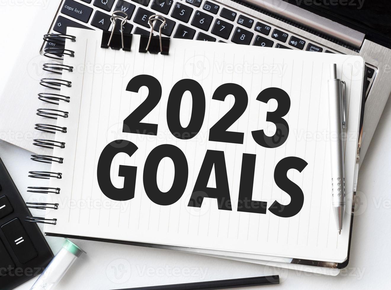 goals 2023 on notebook with laptop and calculator photo