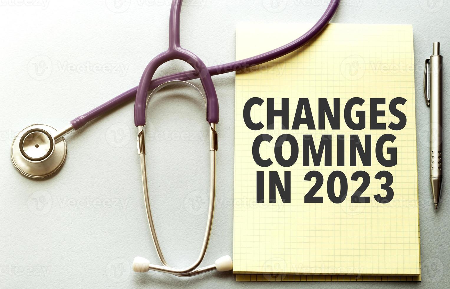 On a purple background a stethoscope with yellow list with text changes coming in 2023 photo