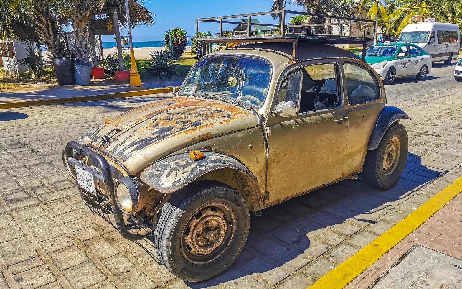 Puerto Escondido Oaxaca Mexico 2022 Old broken rusty and damaged classic vintage cars in Mexico. photo