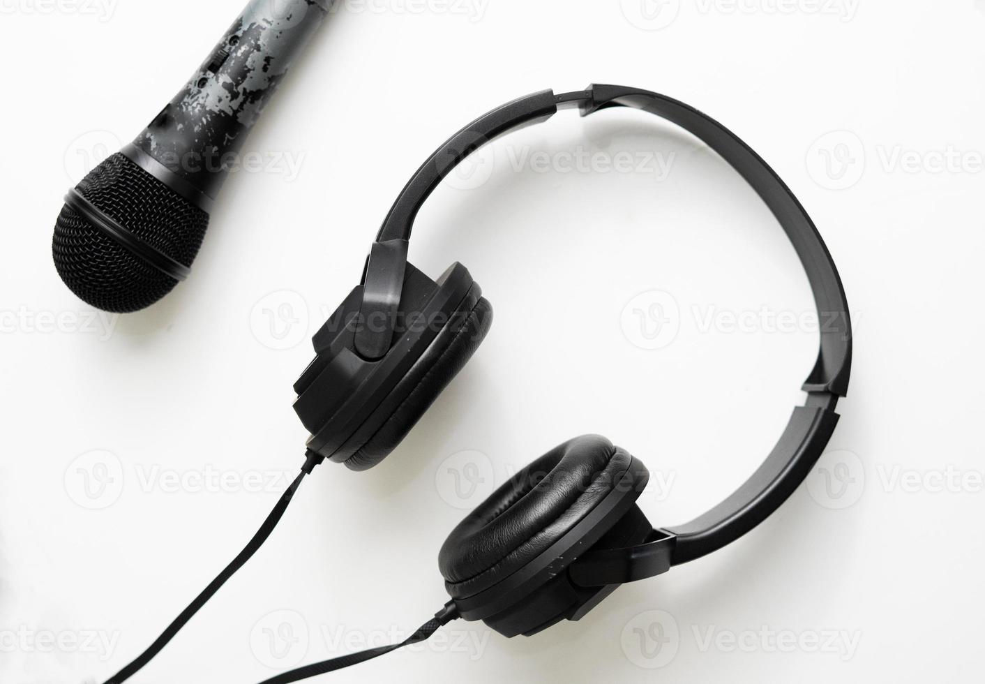 Black microphone and headphone isolated for music and podcast in flat layout background design photo