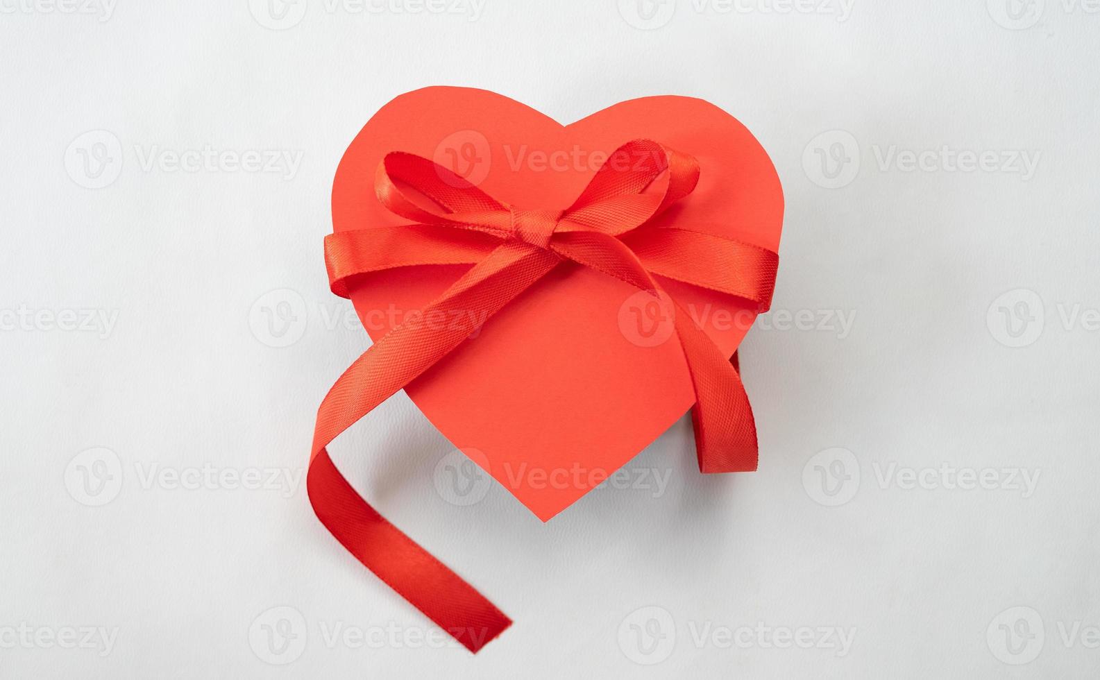 Heart gift box with red ribbon tie. Love shape design element photo