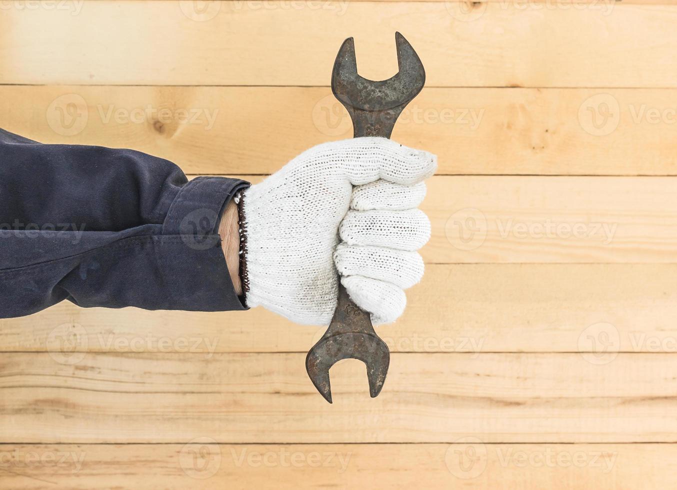 Hand in glove holding spanner photo