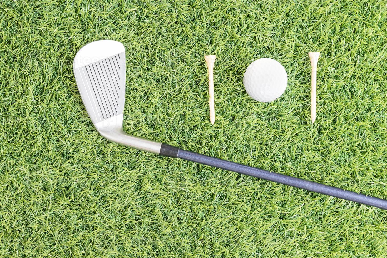 Golf club and golf ball on green grass photo