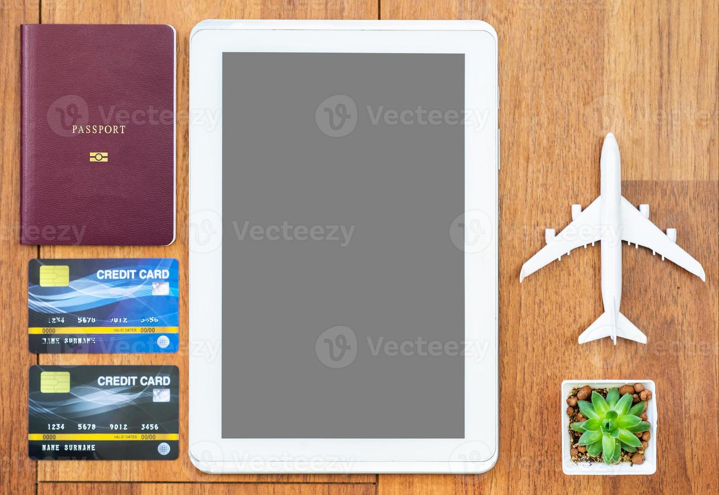 Top view Passport with credit card and digital tablet mock up on wooden desk photo