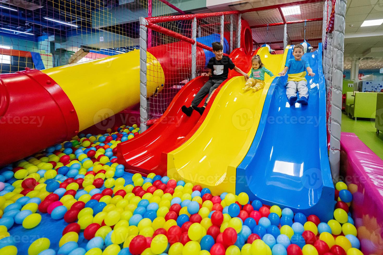 Happy kids playing at indoor play center playground. Children slides in