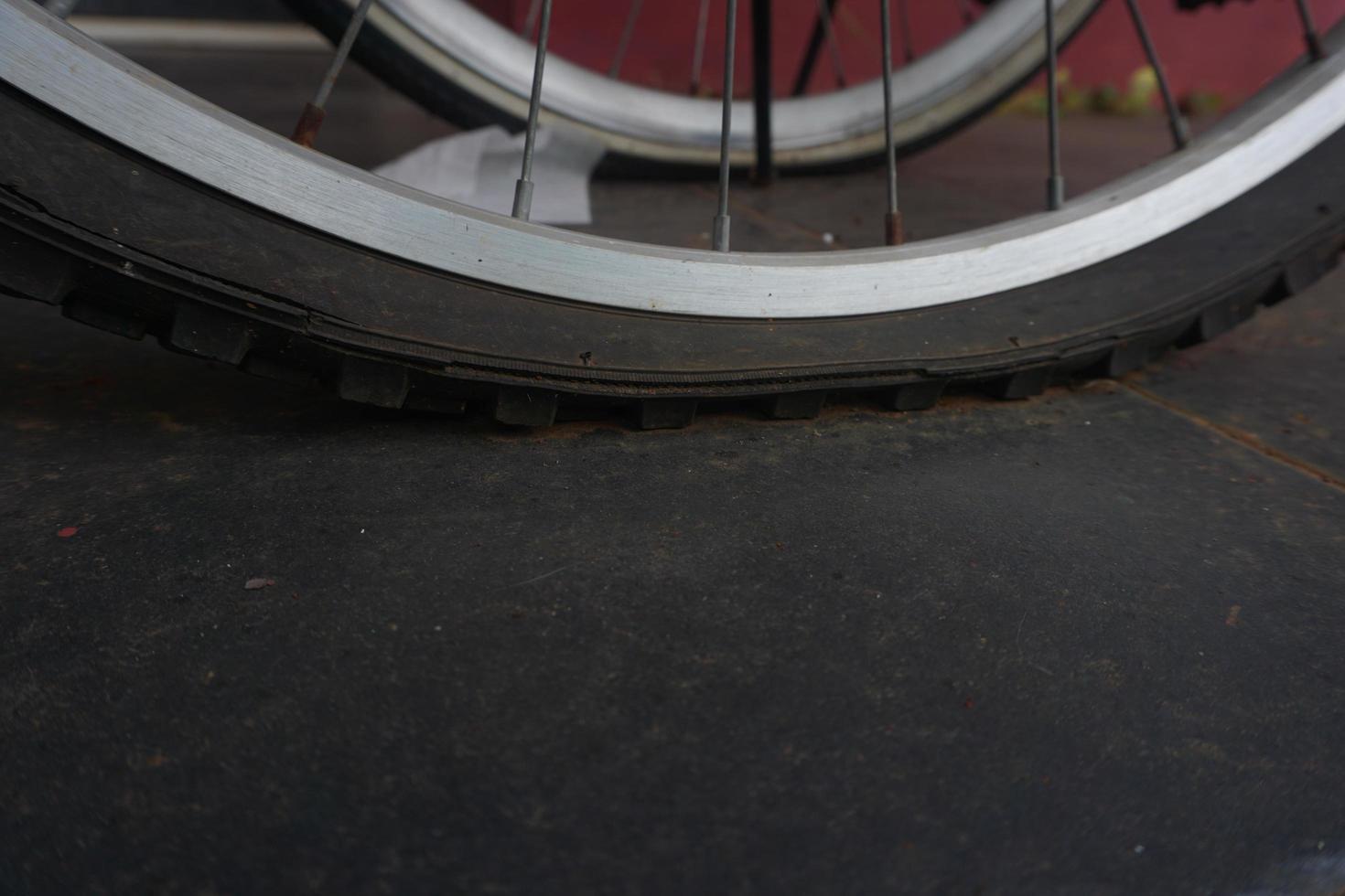 flat bicycle tire in front of the house in the morning photo