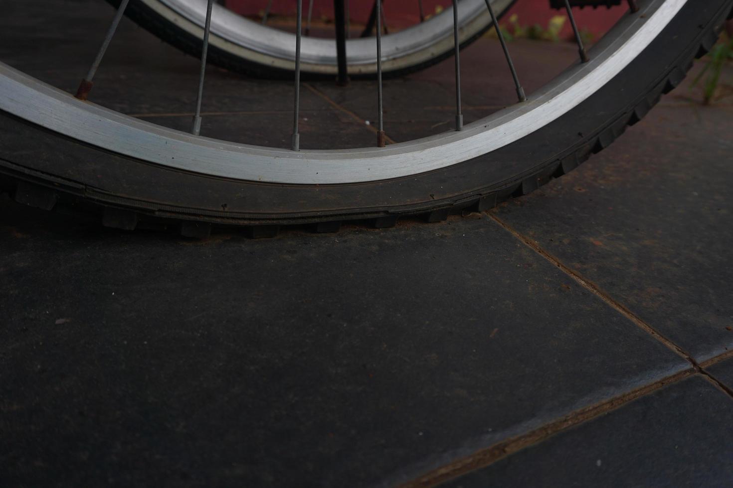 flat bicycle tire in front of the house in the morning photo