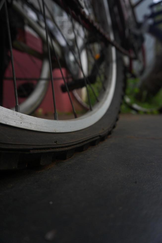 flat bicycle tire in front of the house in the morning photo