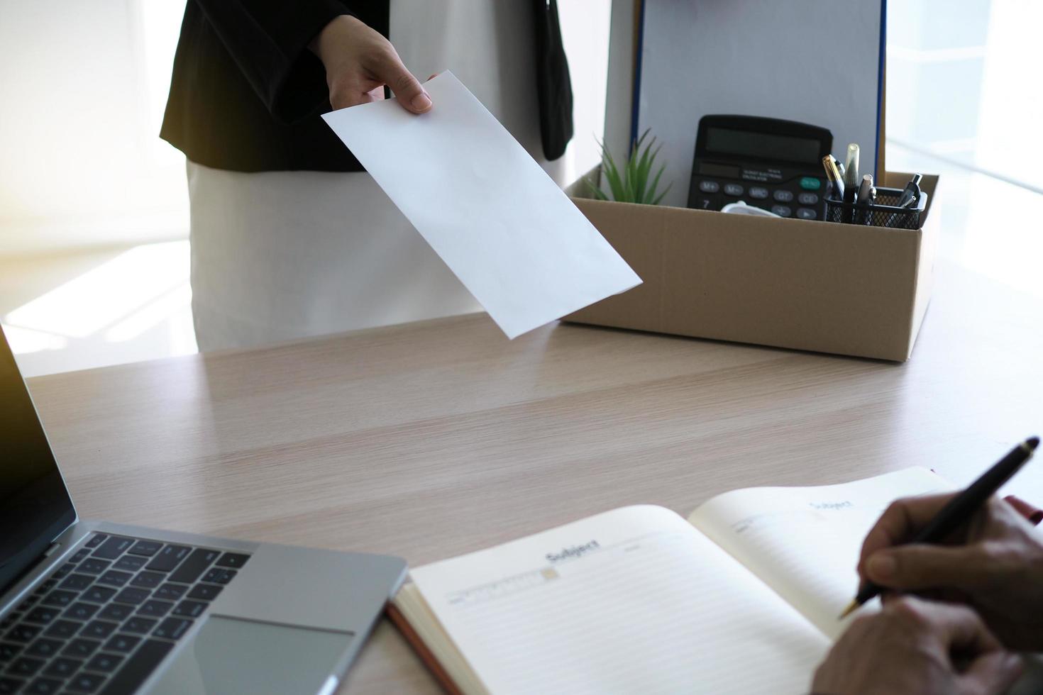 businesswoman have boxes for personal use and are sending resignation letters to executives. Including about resignation from job positions and vacancies. photo