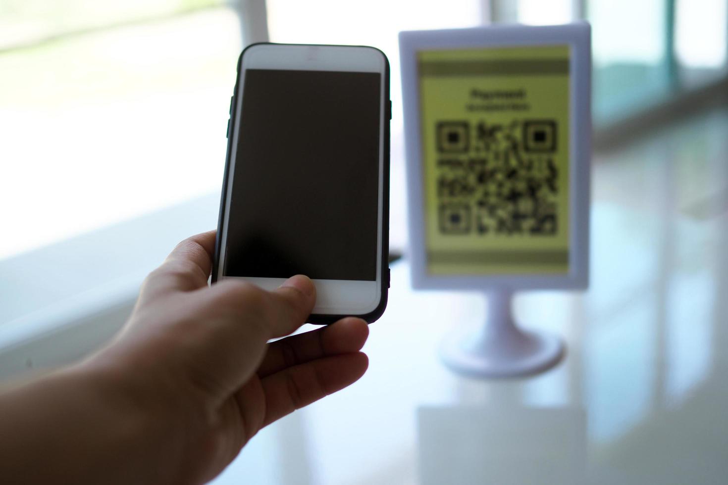 Hands use the phone to scan QR codes to receive discounts on purchases. photo