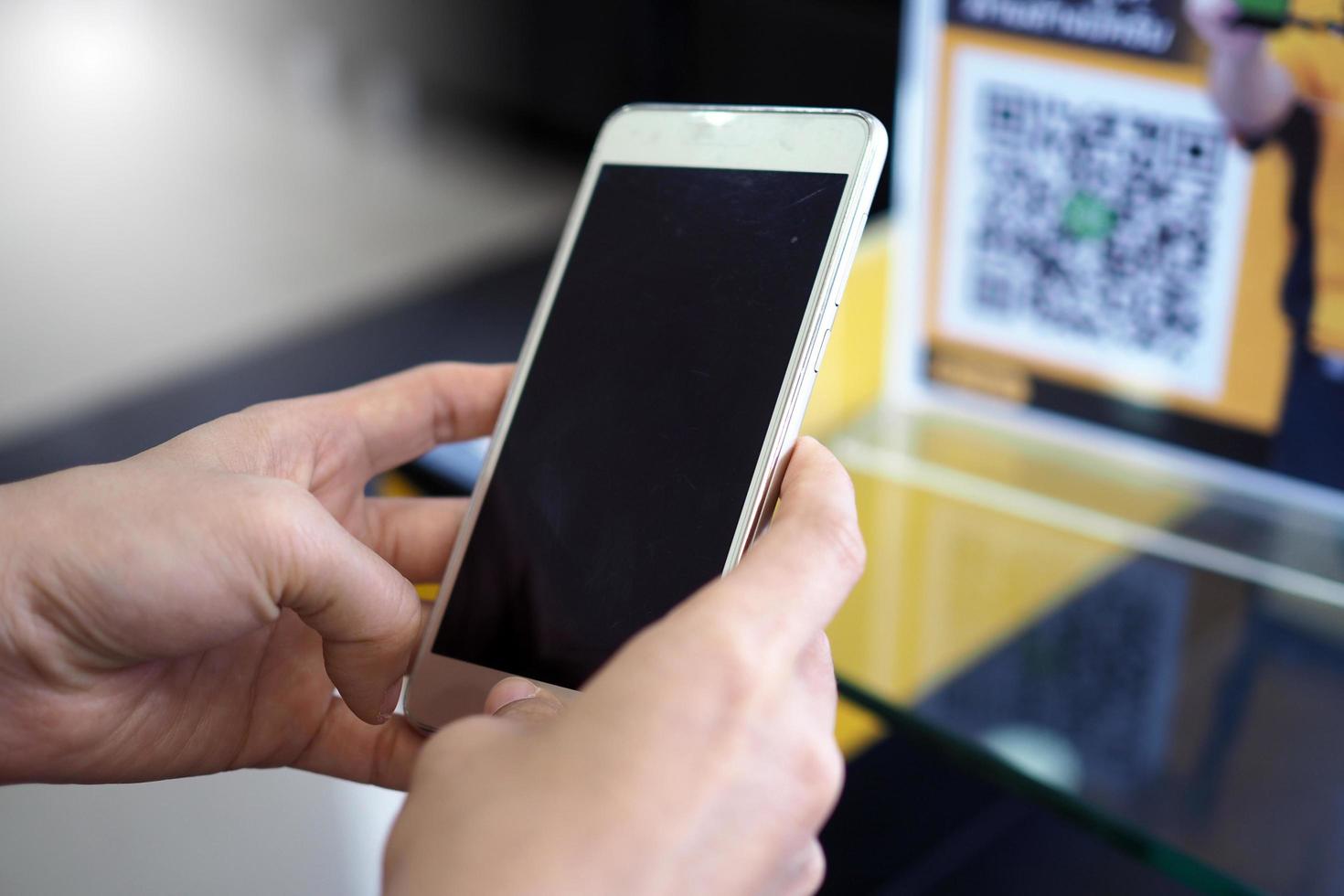 Hands use the phone to scan QR codes to receive discounts on purchases. photo