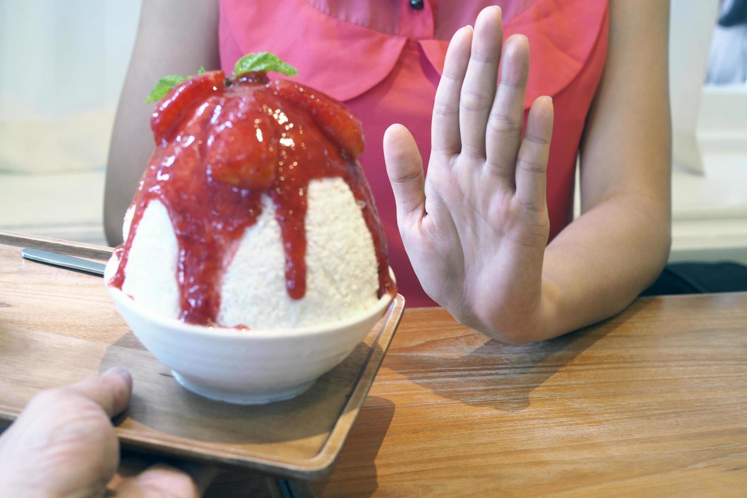 Women push Bingsu cup. Refused to eat all kinds of sweets. Avoid sugar and sweets for good health. diet concept photo