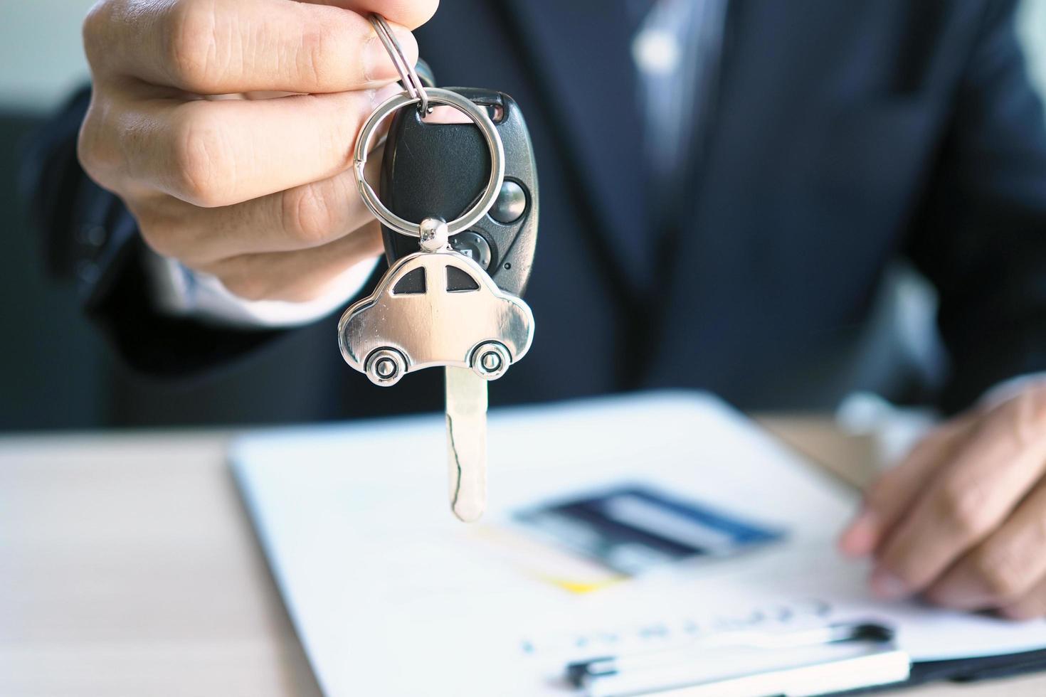 The car salesman and the key to the new owner. photo