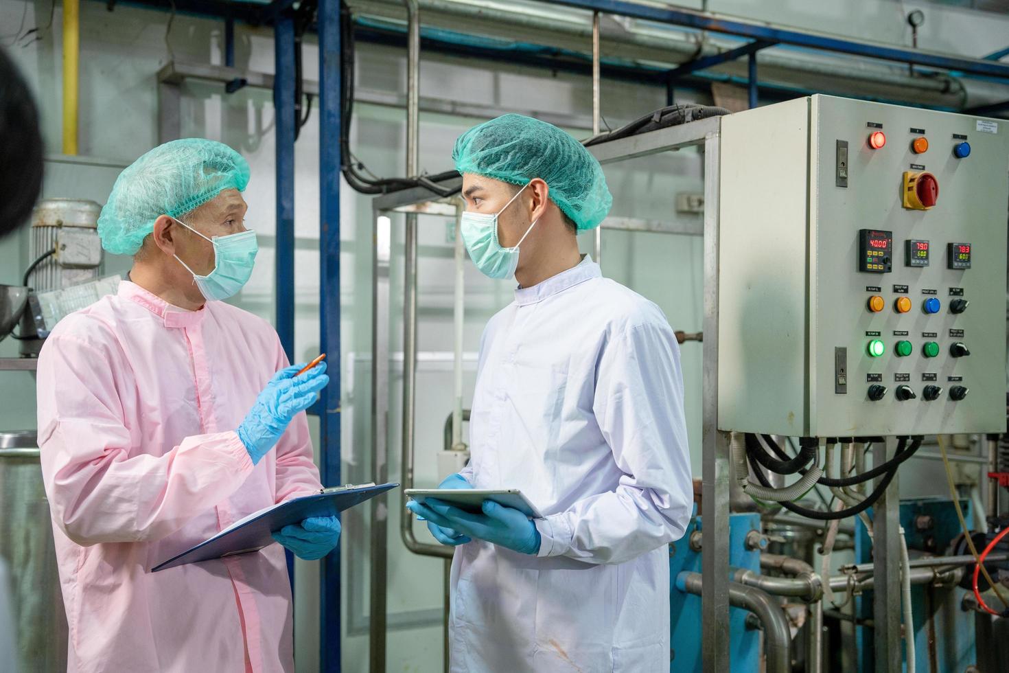 A quality supervisor or food or pharmaceutical technician discuss about process control of food and drugs before send product to the customer. Production leader recheck parameter and productivity. photo