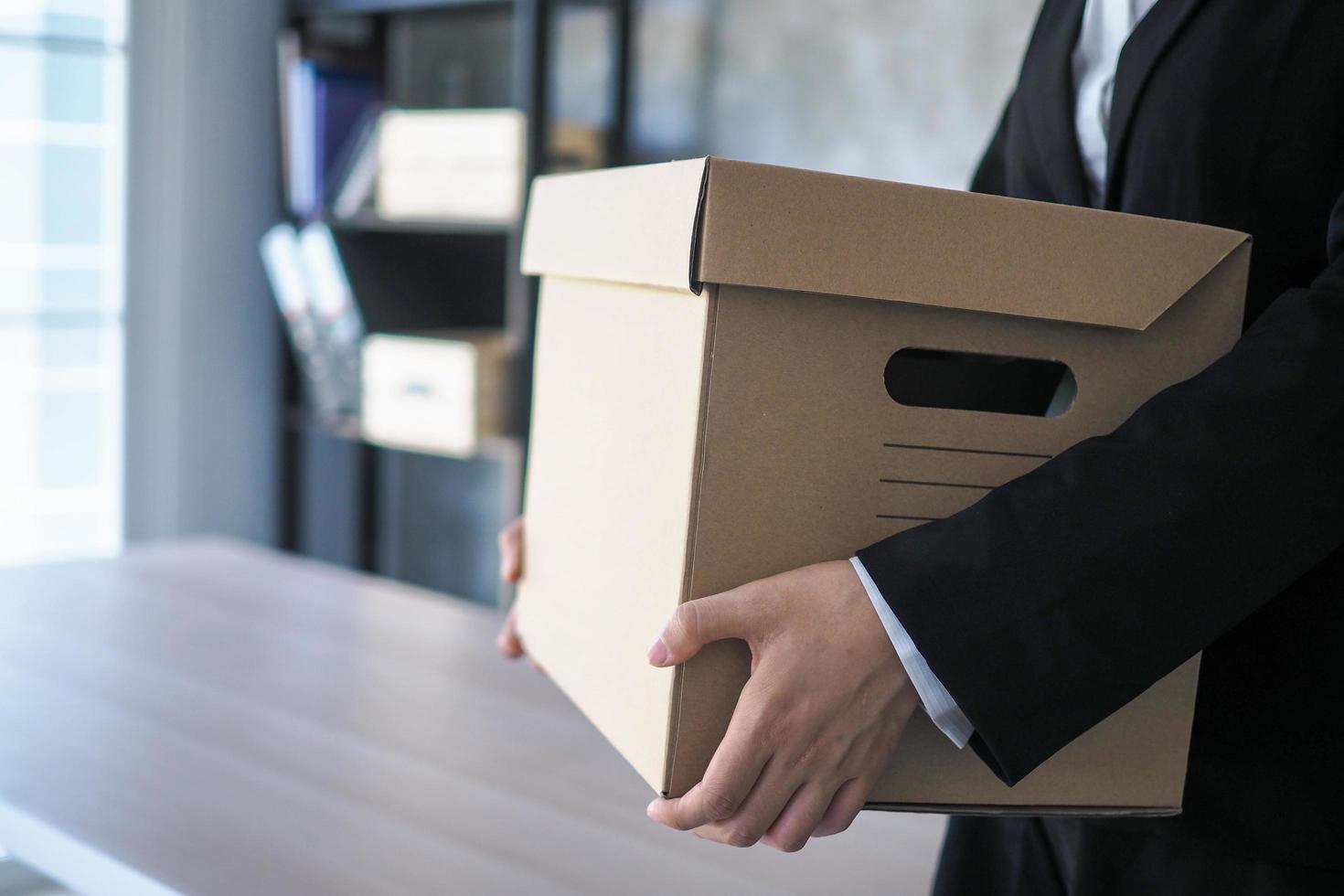 Business people walking and carrying things contain personal items for the job, change brown cardboard boxes, unemployment or resignation ideas photo