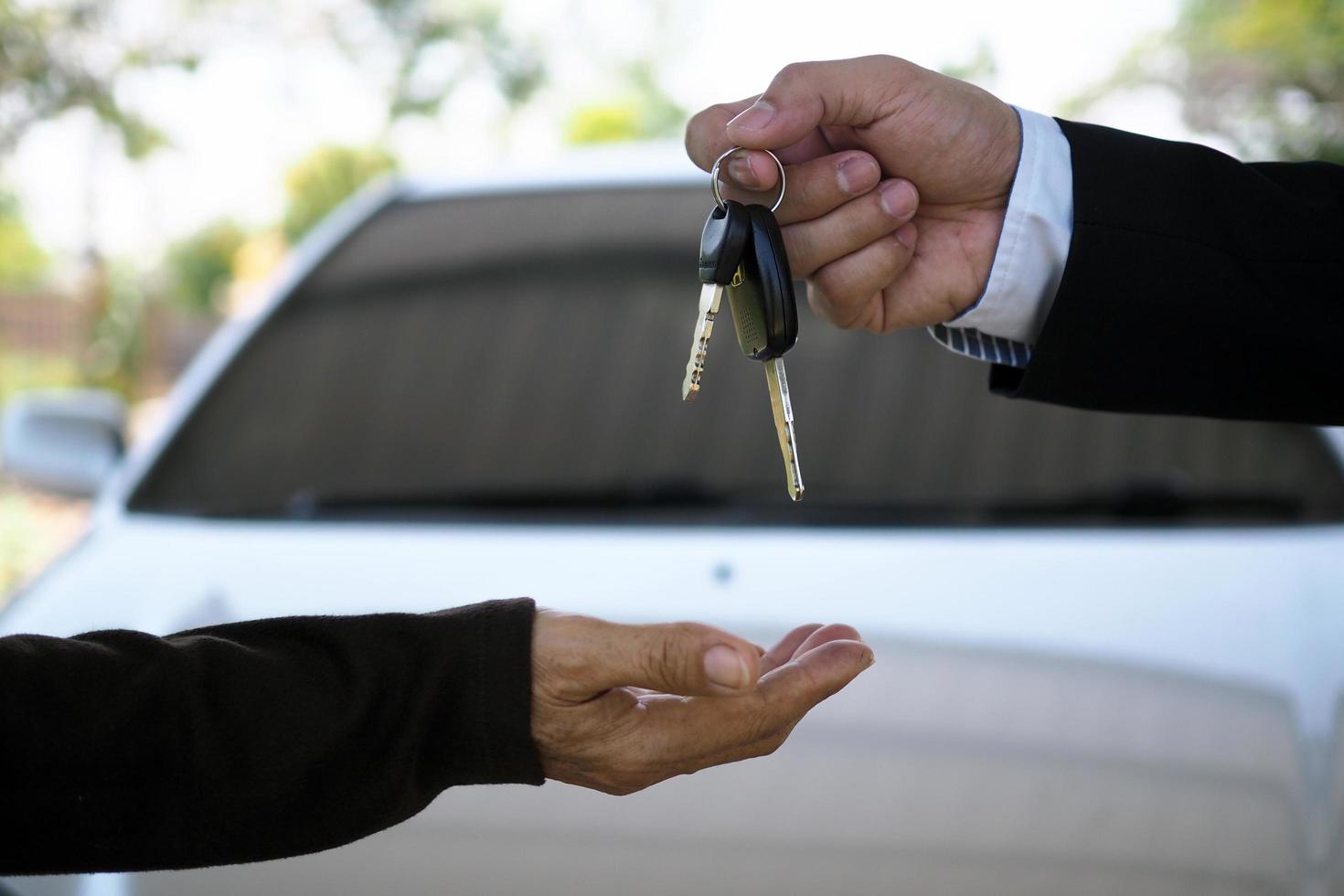 The car salesman and the key to the new owner. photo