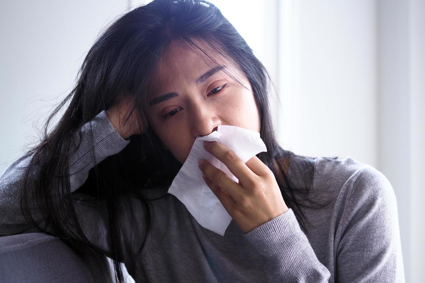 Asian women have high fever and runny nose. Concept of sick people at home photo