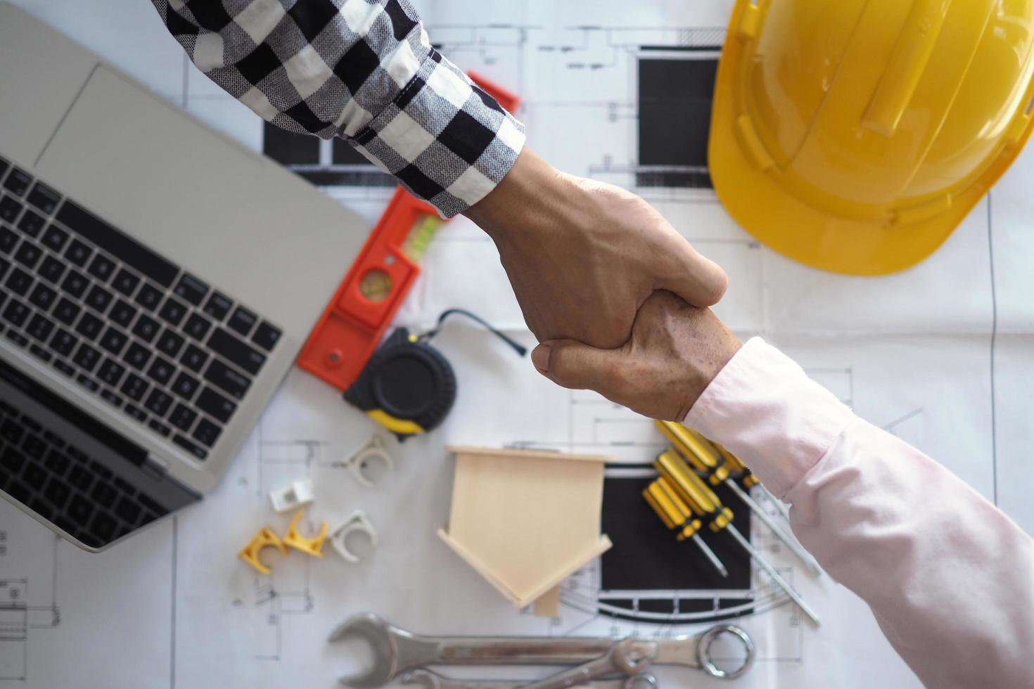 Hand in hand between project contractors and customers due to negotiation of expenses and investments, construction and repair of residential buildings. photo
