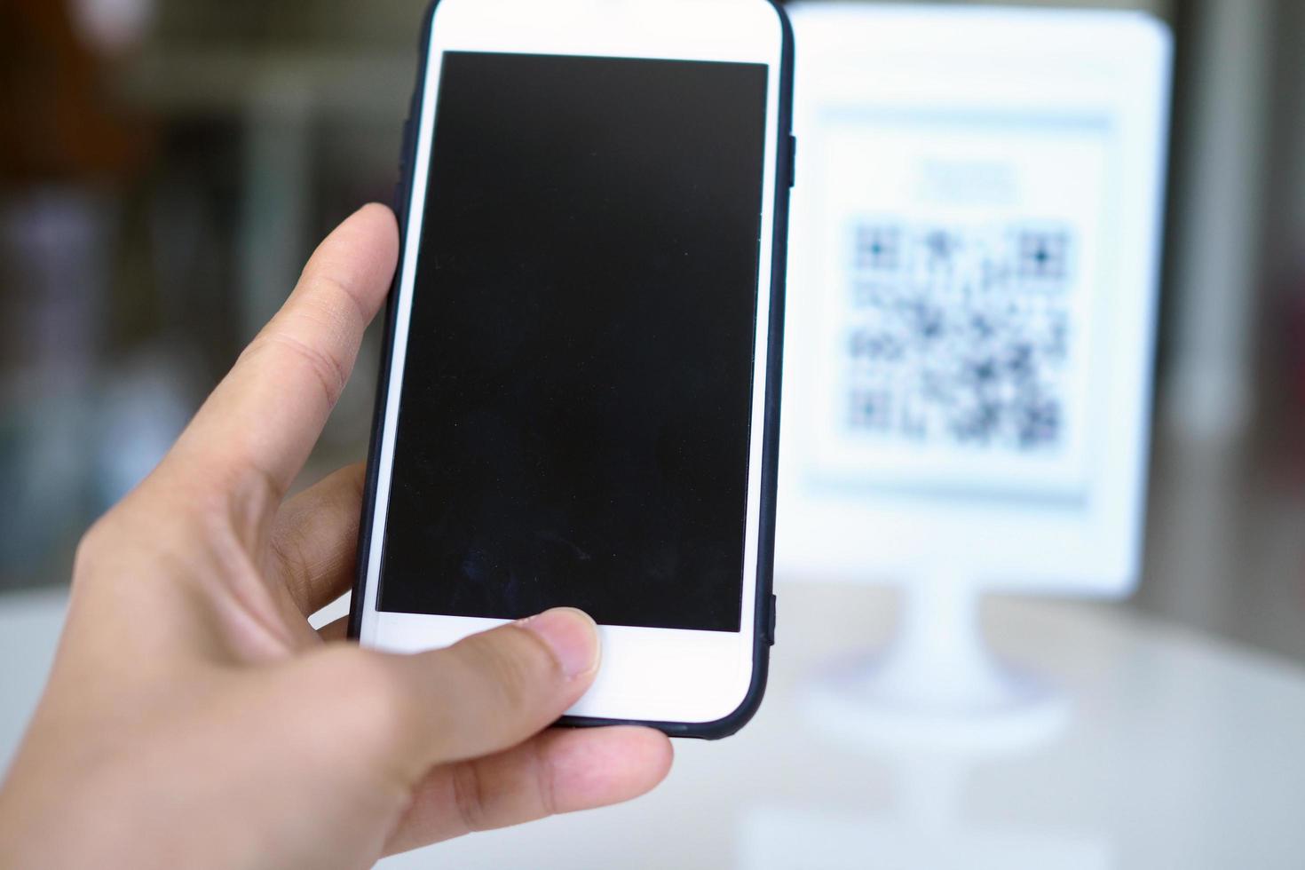 Hands use the phone to scan QR codes to receive discounts on purchases. photo