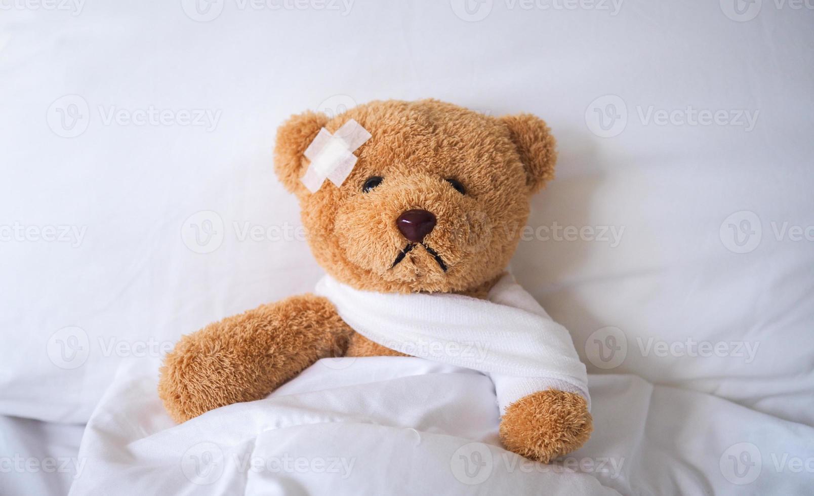 The teddy bear fell ill in the bed, injured by the accident. insurance concept photo