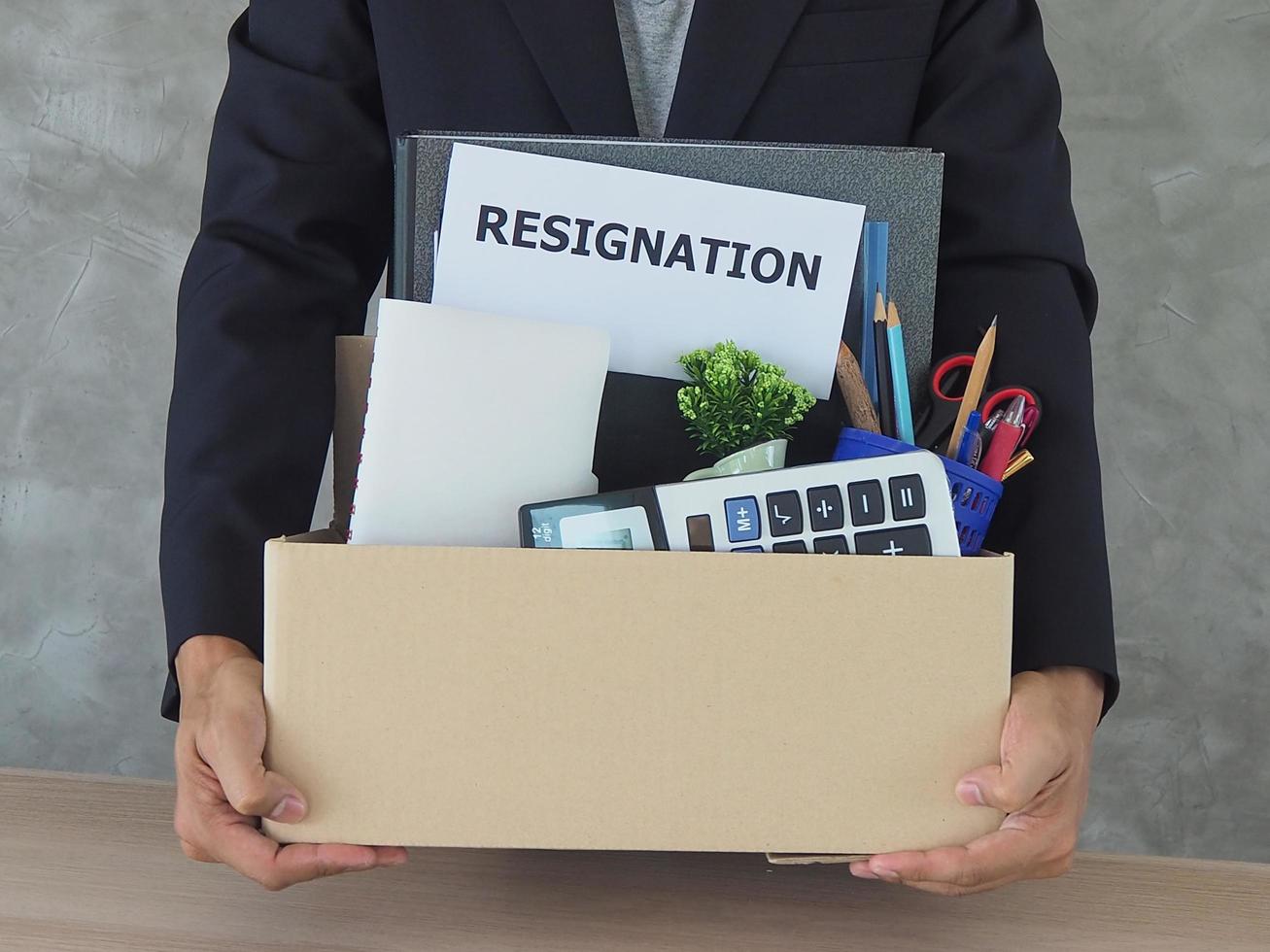 Businessmen hold boxes for personal belongings and resignation letters. photo