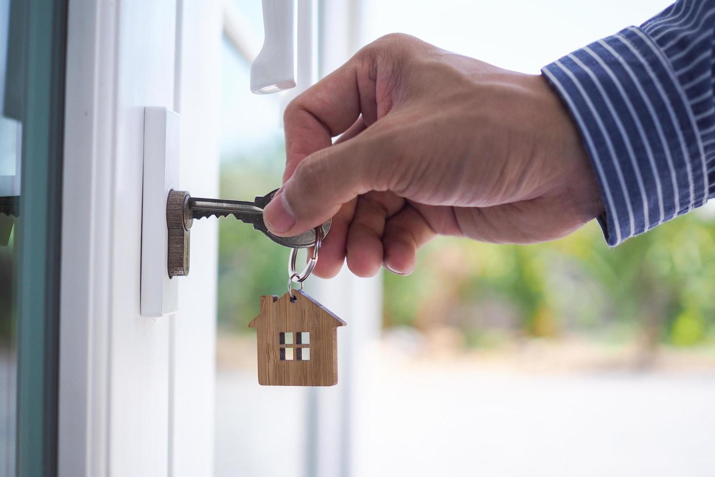 el propietario abre la llave de la casa para un nuevo hogar. foto