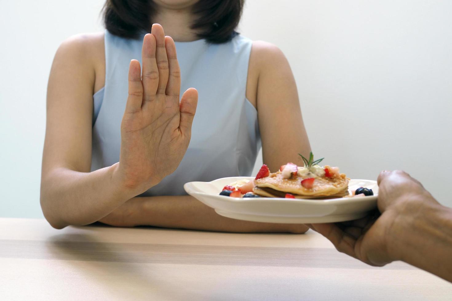 The women used to push the dessert plate with the people.  Do not eat desserts for weight loss. photo