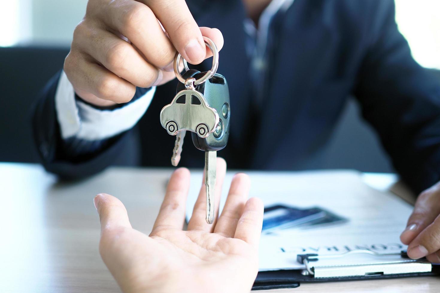 The car salesman and the key to the new owner. photo