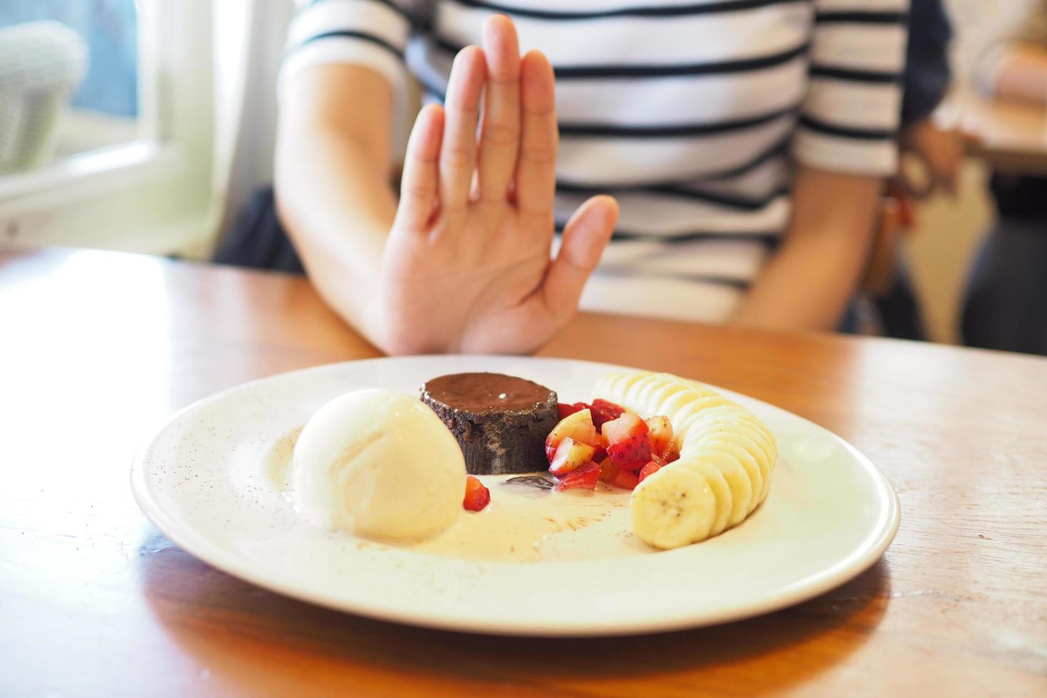 las mujeres empujaban el plato de postre con la gente. No comas postres para bajar de peso. foto