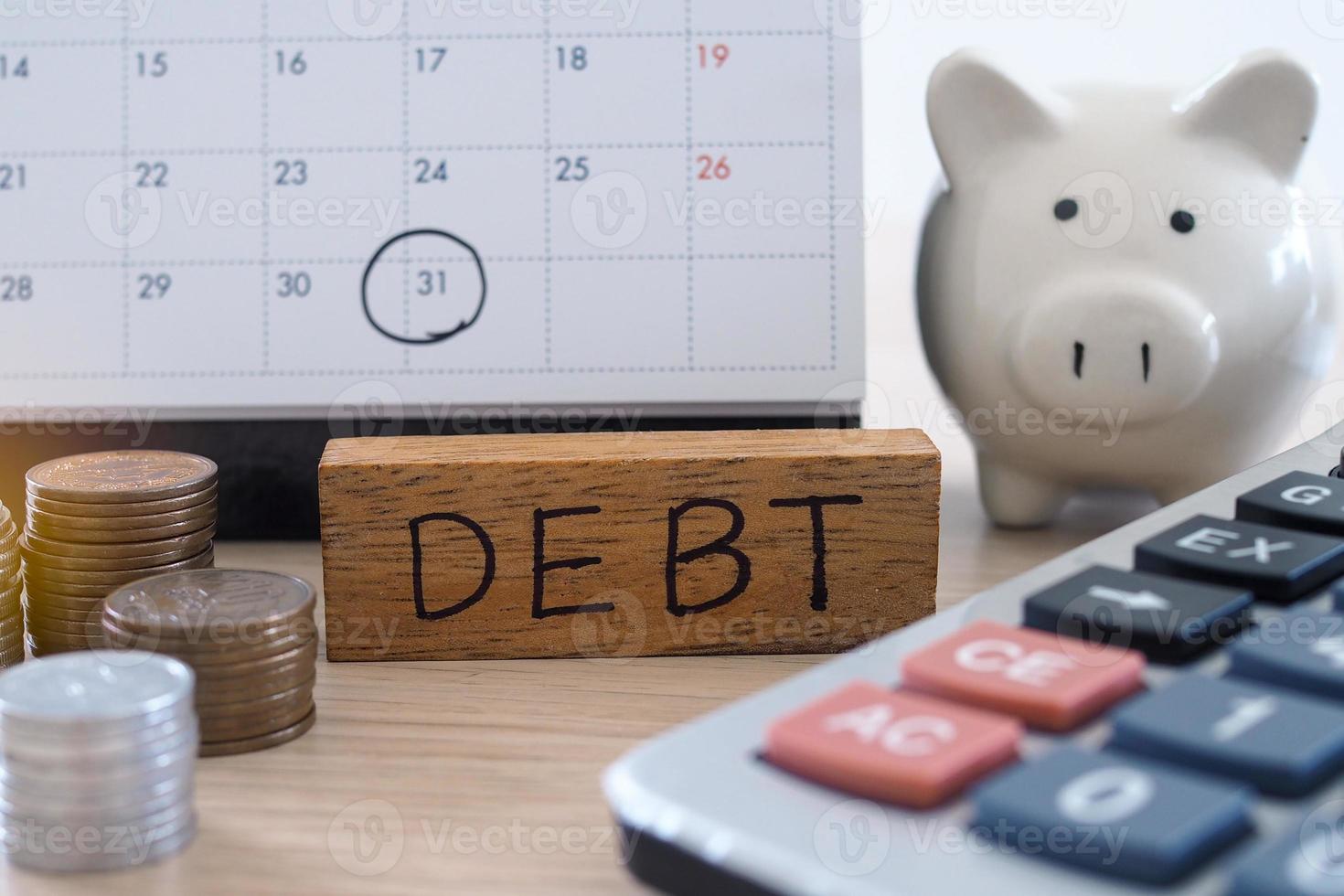 By throwing a clean white calendar, specify debt, expenses that will arrive on the last day of the month that must be paid. Calculator, Coin Stack and Piggy Bank in picture photo