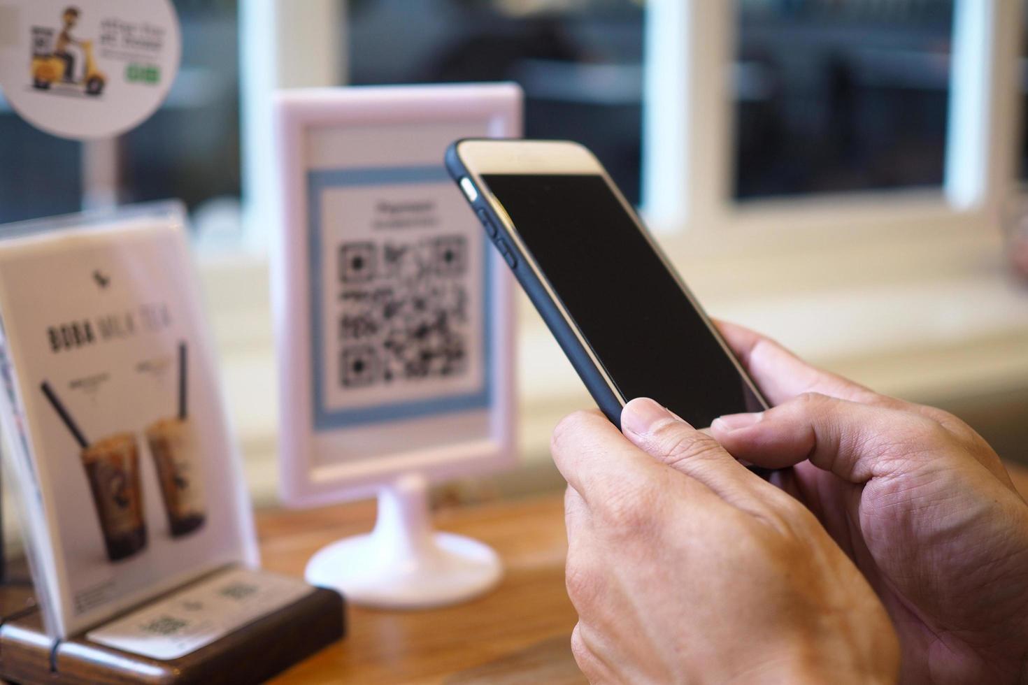 Hands use the phone to scan QR codes to accumulate points in restaurants. photo