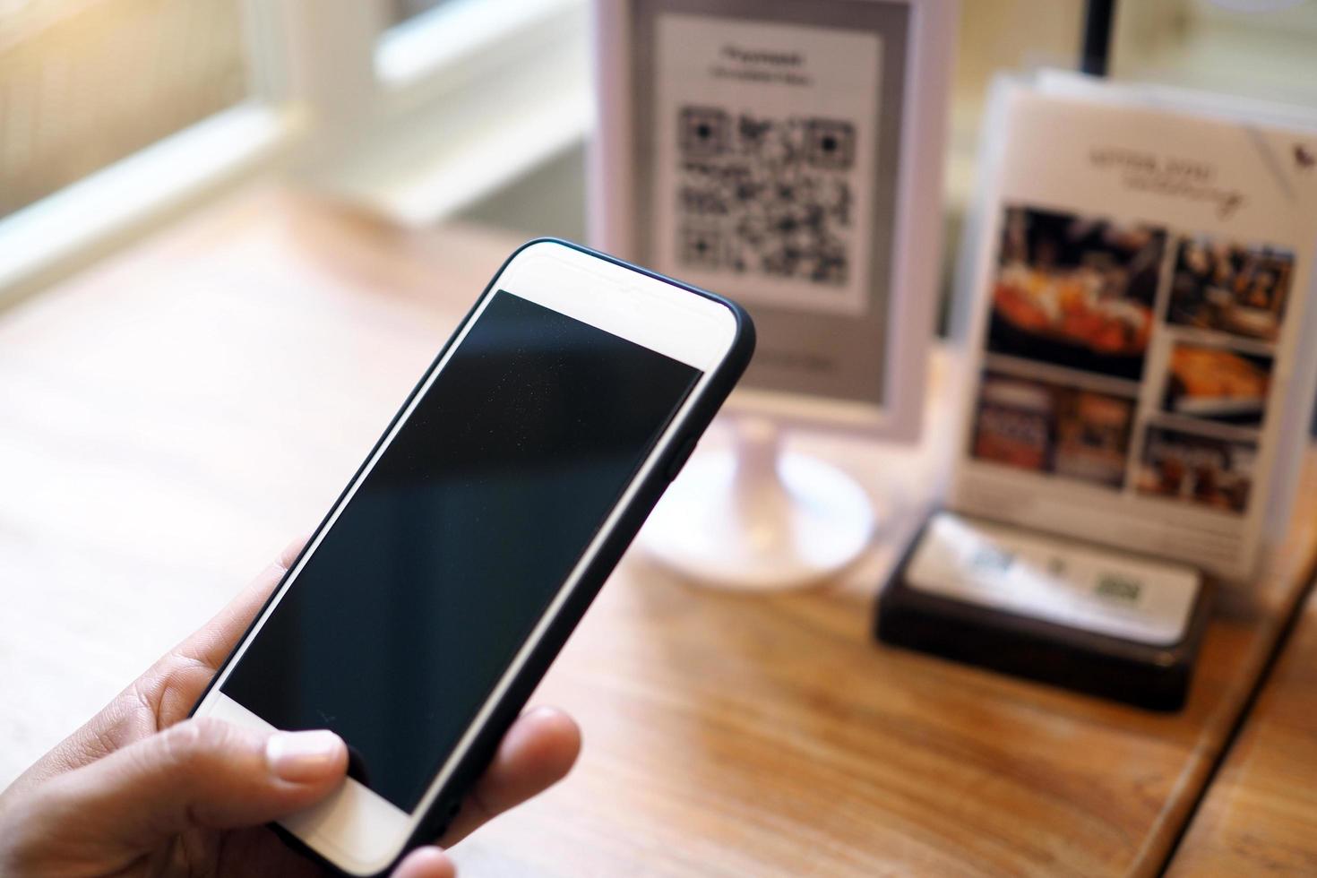 Hands use the phone to scan QR codes to accumulate points in restaurants. photo