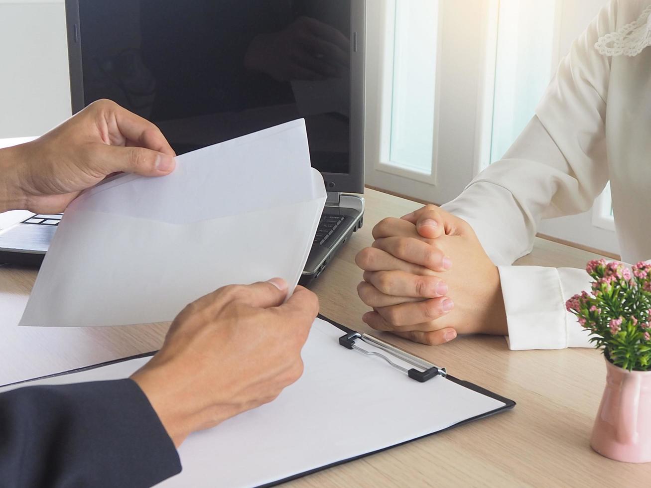 Women work out a resignation letter to the staff of the scare. And the boss of the scarecrow is opening a letter of resignation. Resignation concept photo