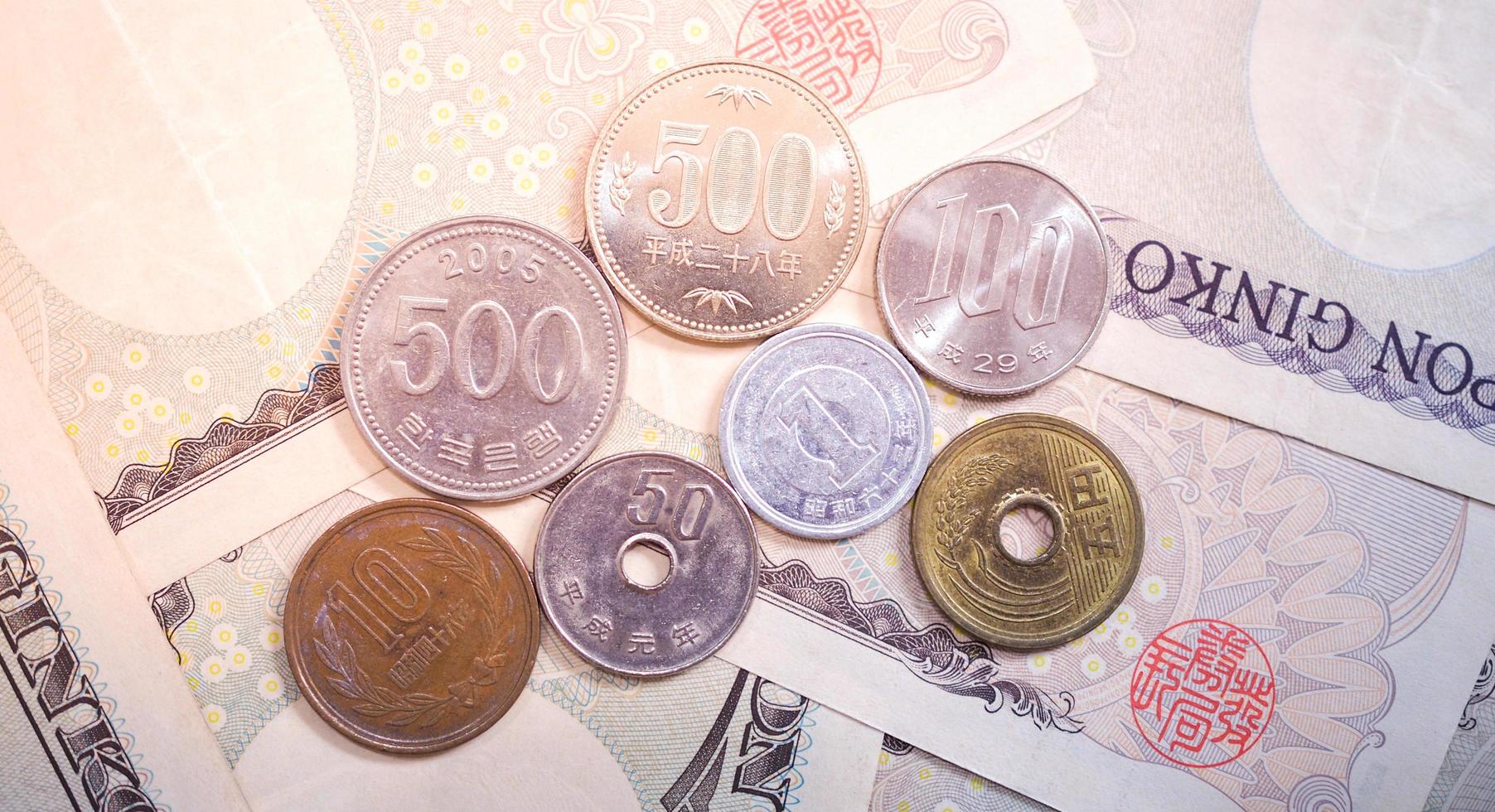 billetes de yen japonés y monedas de yen japonés por concepto de fondo de dinero foto