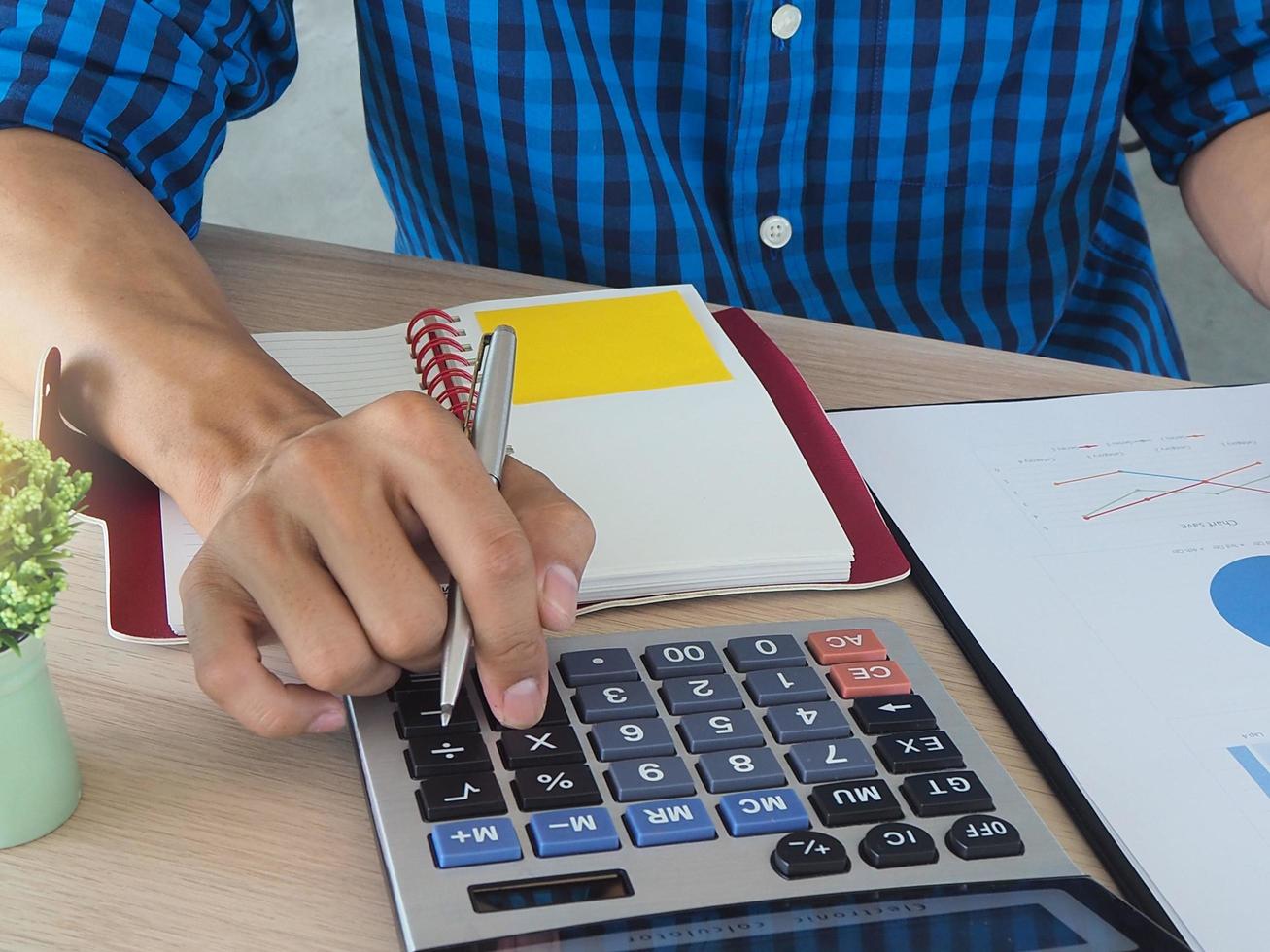 Men are pressing the calculator. Calculate the data. Work in the office concept. photo