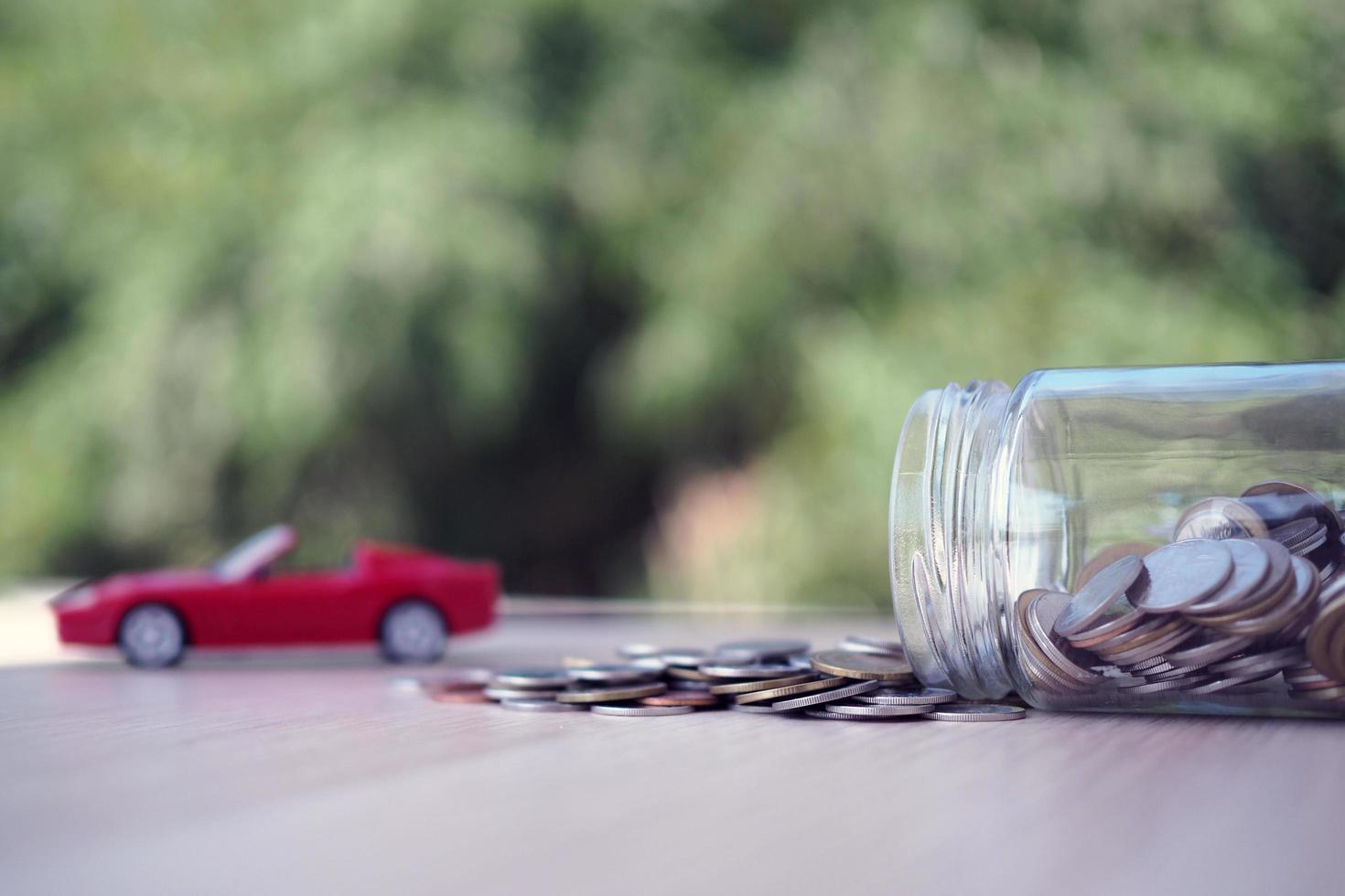 Coin jar and car model Represents the debt from buying a car. debt or save concept photo