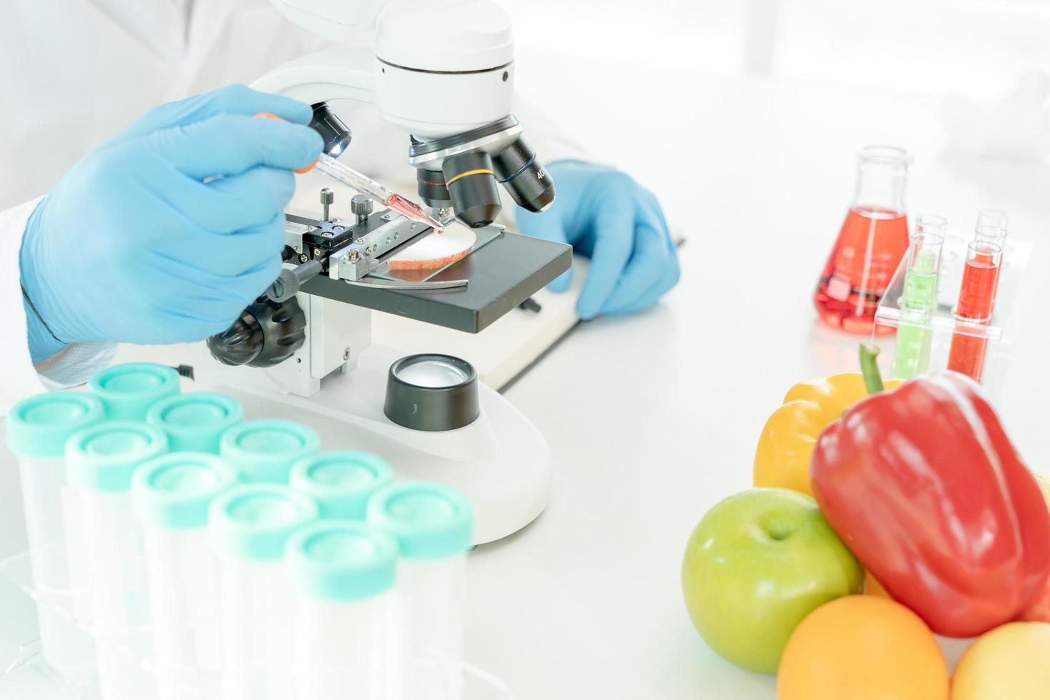 el científico comprueba los residuos de alimentos químicos en el laboratorio. expertos en control inspeccionan la calidad de frutas, verduras. laboratorio, peligros, rohs, encontrar sustancias prohibidas, contaminar, microscopio, microbiólogo foto