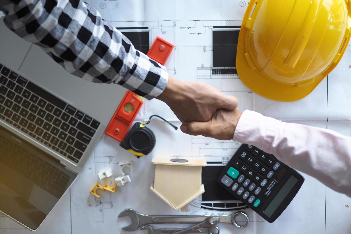 Hand in hand between project contractors and customers due to negotiation of expenses and investments, construction and repair of residential buildings. photo