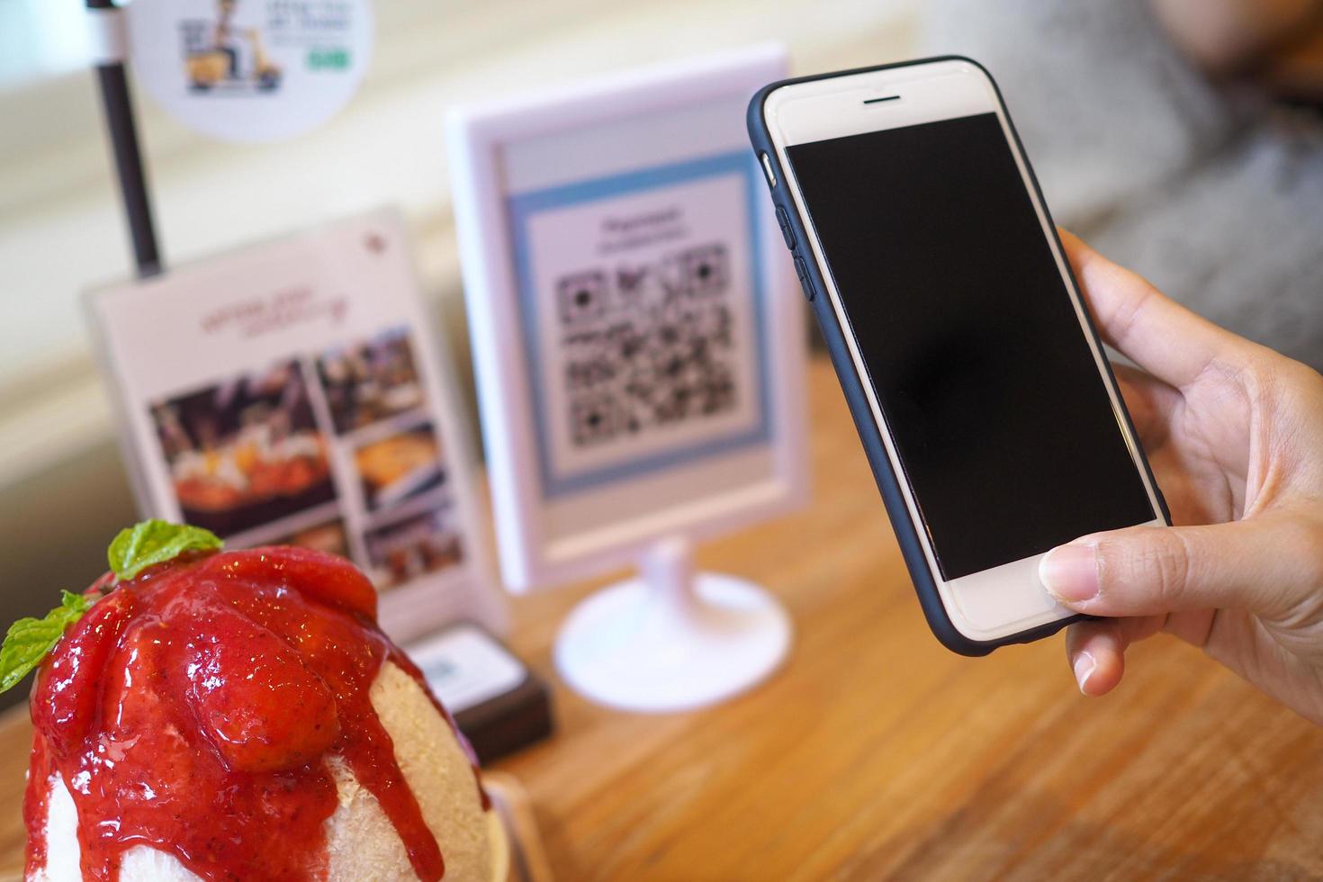 Hand use the phone to scan the barcode to get the discount in the cafe shop photo