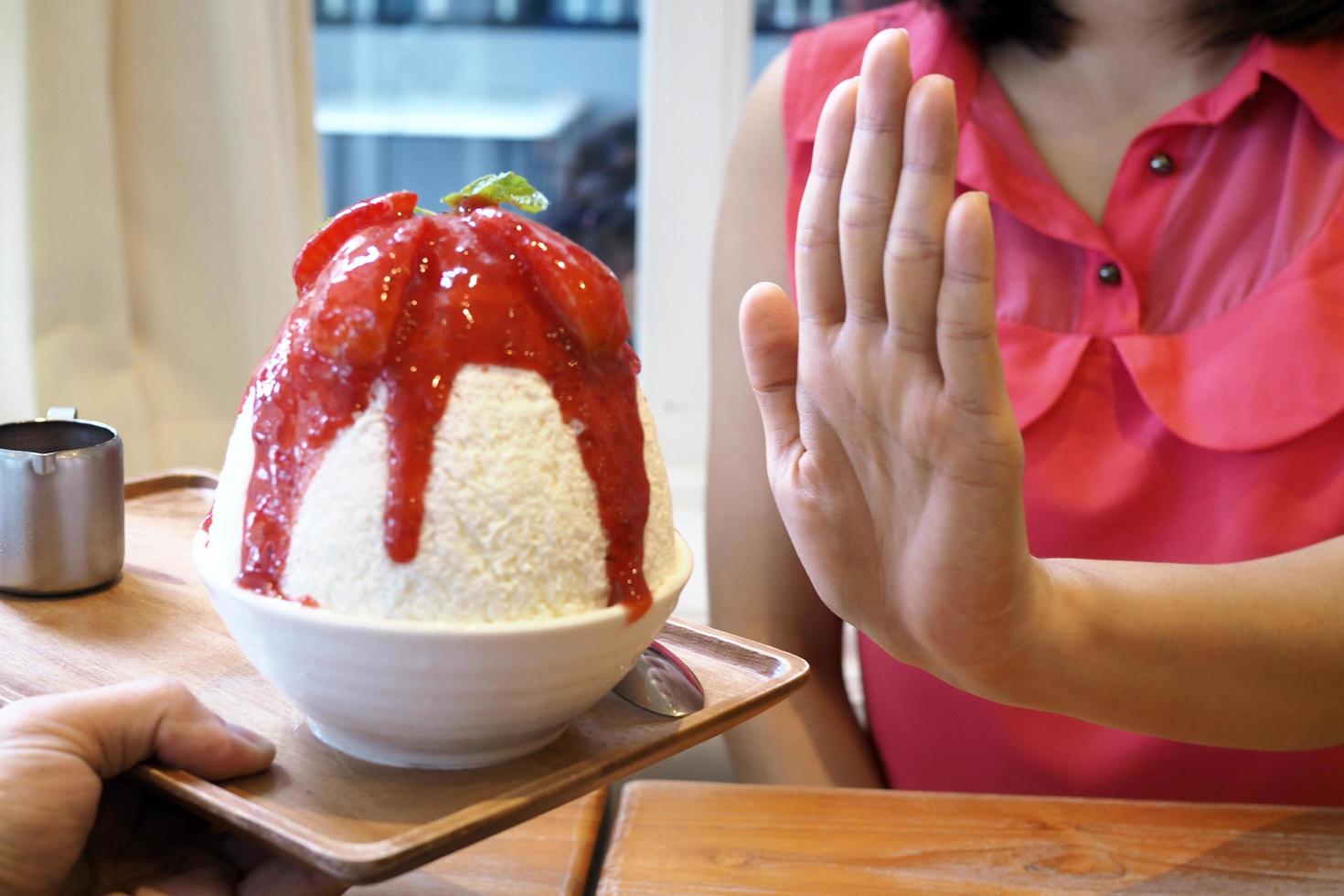 las mujeres empujan la copa de helado. se negaba a comer todo tipo de dulces. evitar el azúcar y los dulces para una buena salud. concepto de dieta foto