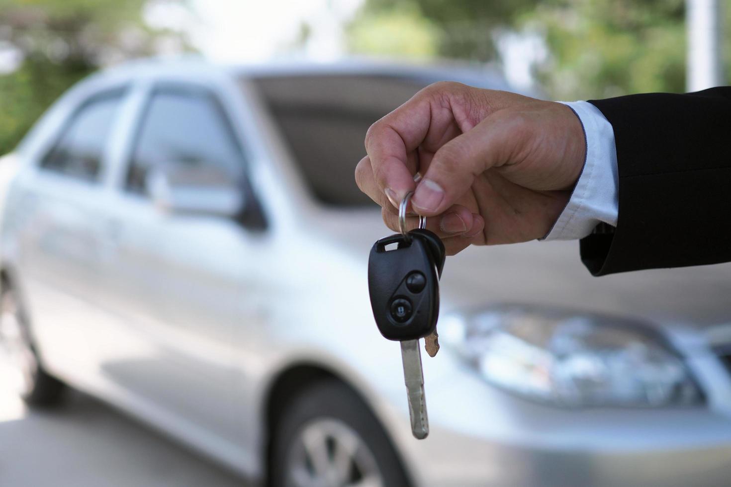 The car salesman and the key to the new owner. photo