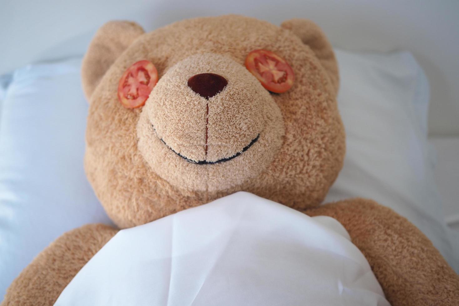 Brown teddy bear, relax from the process of spa eye mask with tomatoes photo