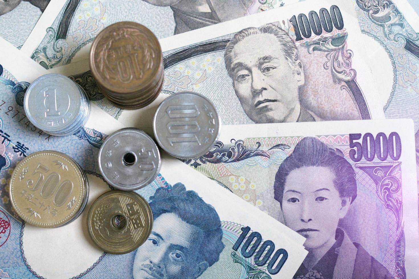 billetes de yen japonés y monedas de yen japonés para el fondo del concepto de dinero. la imagen tiene luz violeta. foto