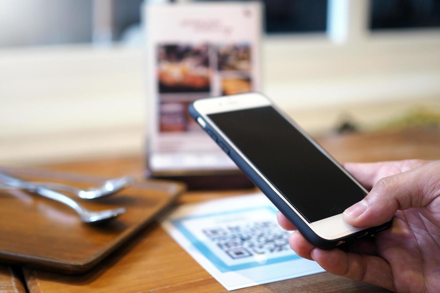 Hands use the phone to scan QR codes to accumulate points in restaurants. photo