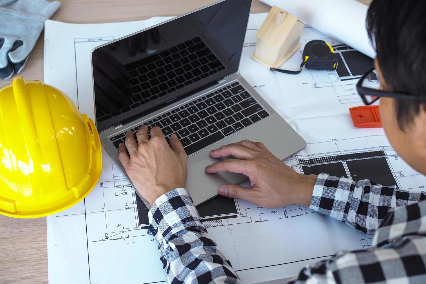 Engineers work with laptops and blueprints. Calculate and check the construction project photo