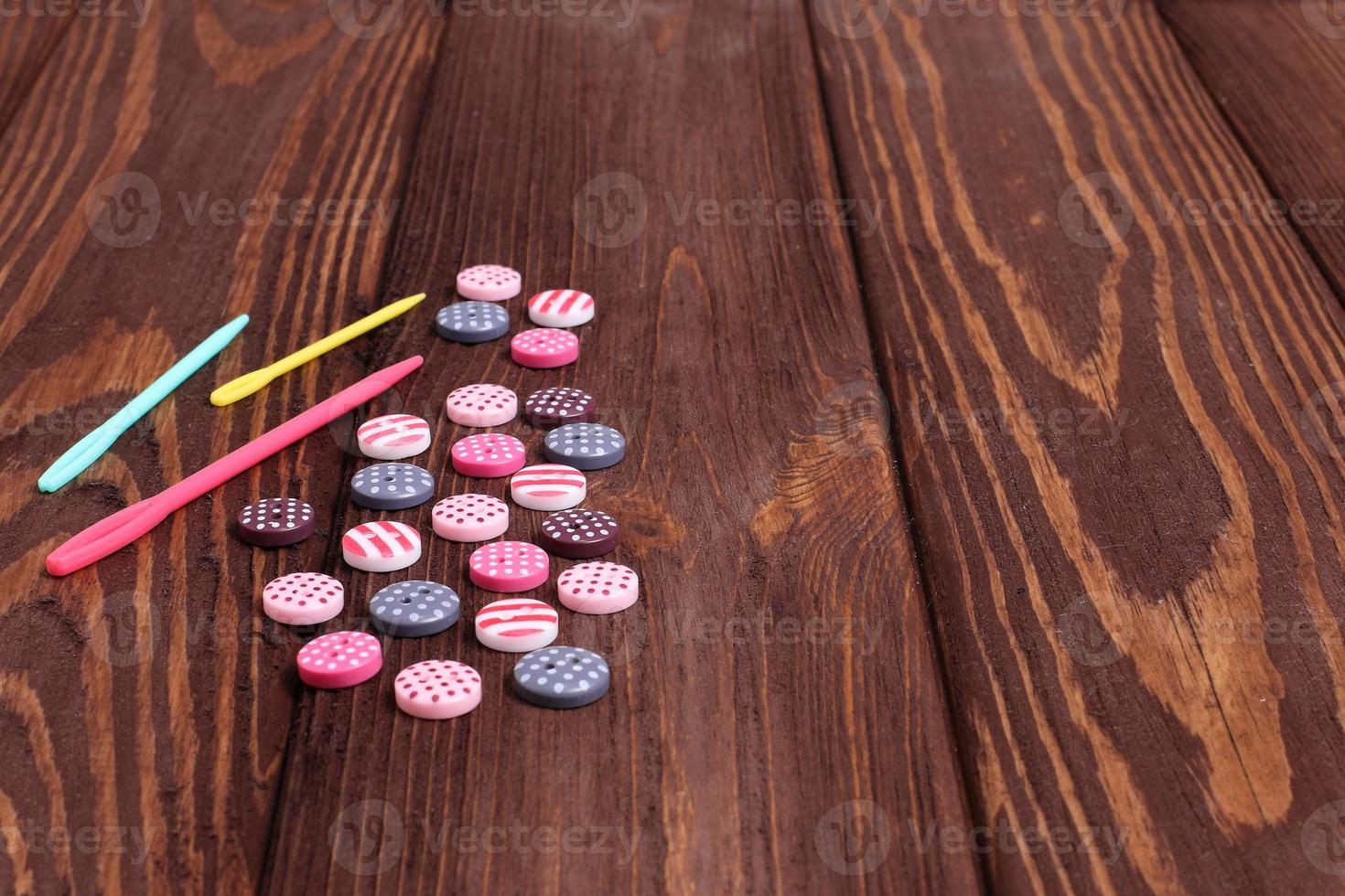 Group of buttons for sewing work on wooden table photo