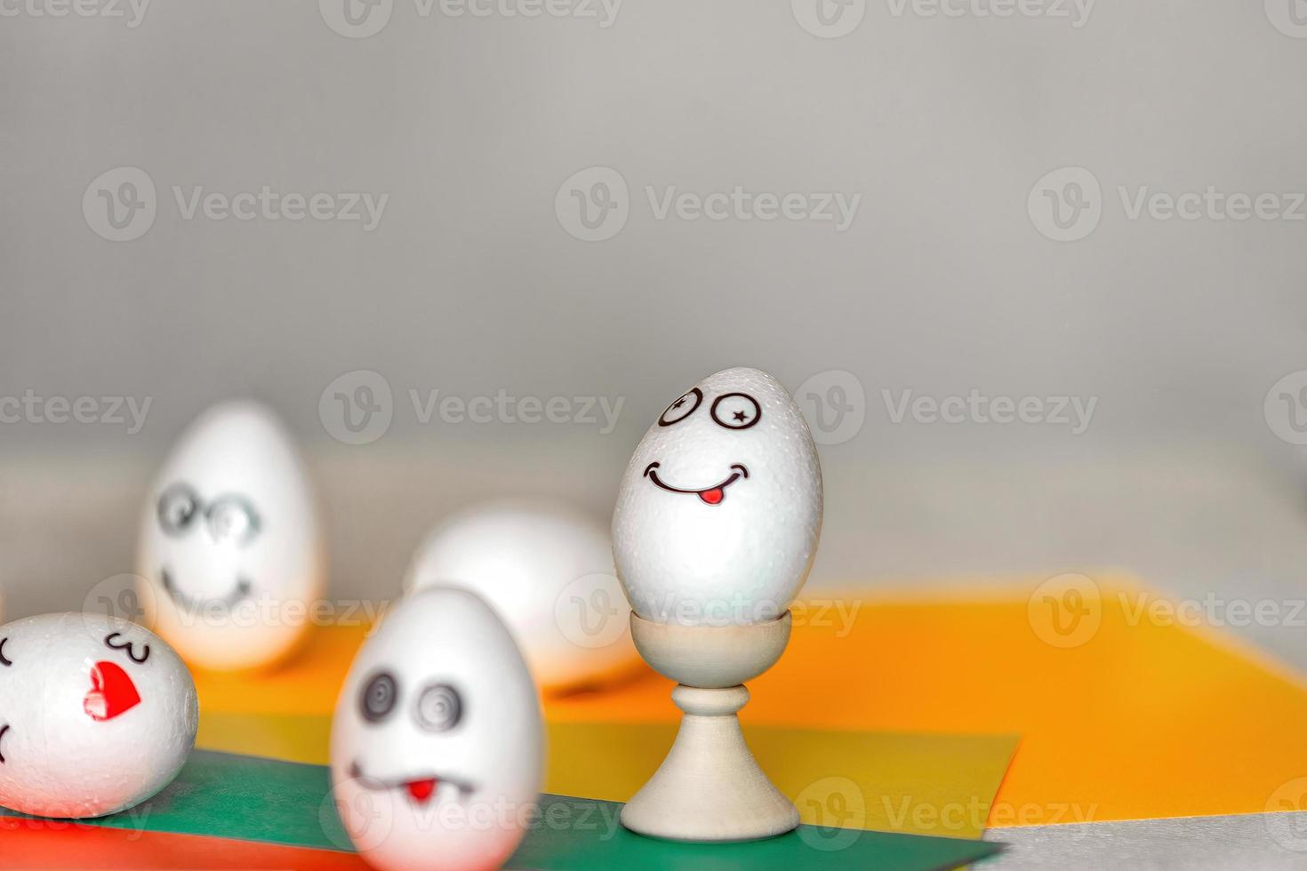 se pegan pegatinas con diferentes emociones en huevos blancos, espacio de copia .el concepto de comunicación y emociones en las redes sociales, decoración inusual de huevos de Pascua foto